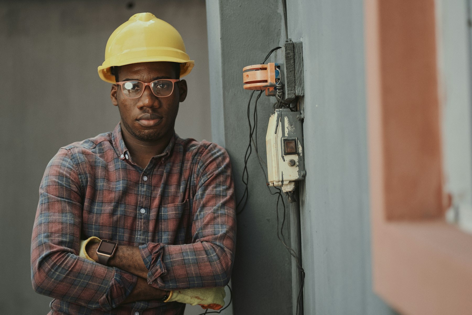 Engineer in a hard hat leaning against a wall